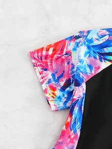 Close-up of girls swimwear short sleeve with vibrant floral print and fine stitching