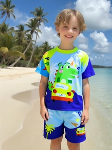 Detail of boys' swimwear set featuring cartoon crocodile and beach print in blue