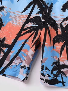 Gros plan sur l'imprimé palmier tropical et les coutures de ce short de bain pour garçon