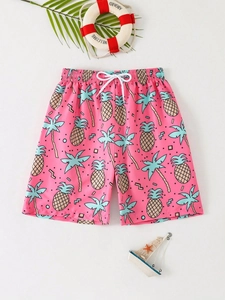 Detail of kids pink beach shorts featuring pineapple prints and elastic waistband