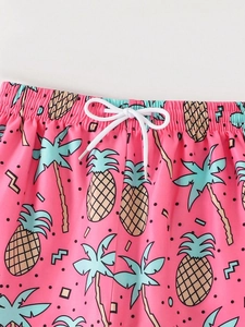 Macro shot of tropical pink kids beach shorts with pineapple and palm tree prints