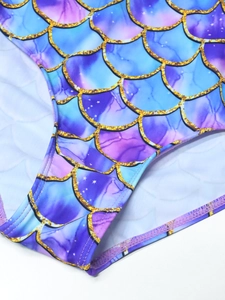 Macro view of blue-purple gradient mermaid scales with gold glitter and stitching