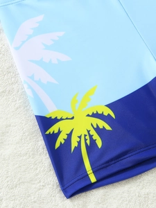 Close-up of boys' swimwear fabric with tropical coconut tree patterns and blue stitching