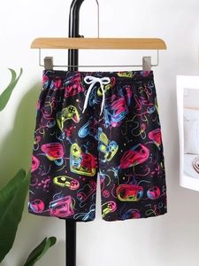 Detail of boys beach shorts with neon gamepad prints and white drawstring closure