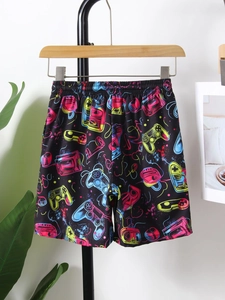 Detail of quick-dry black boys' beach shorts featuring colorful neon gaming graffiti print