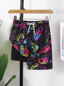 Detail of boys beach shorts with neon gamepad prints, elastic waist and white drawstring