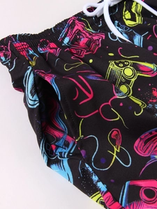 Detail of boys' quick-dry beach shorts featuring elastic waistband and neon gaming prints