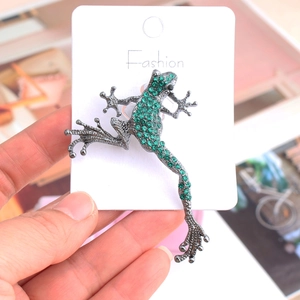 Green crystal frog brooch with antique finish on a fashion card for suit accessories