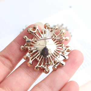 Back view of gold alloy sunflower brooch showing secure safety pin clasp and metal texture