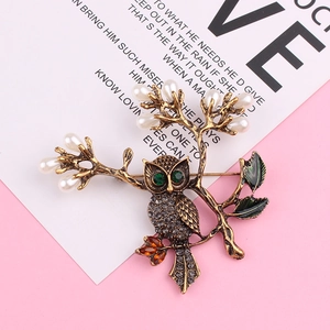 Broche chouette vintage avec yeux verts et strass gris sur branche de perles