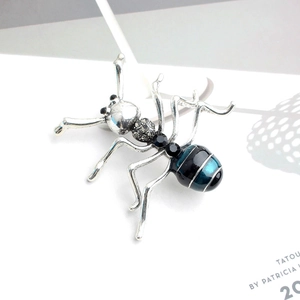 Gros plan détaillé d'une broche fourmi vintage en métal avec émail bleu et noir élégant