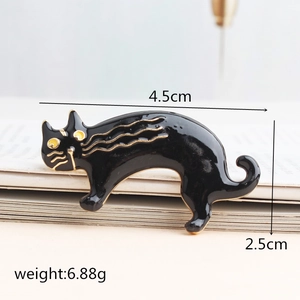 Elegante broche de gato en esmalte negro con contornos dorados y ojos amarillos