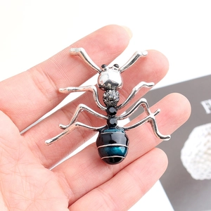 Gros plan d'une broche fourmi avec strass noirs et perles dégradées bleu et noir