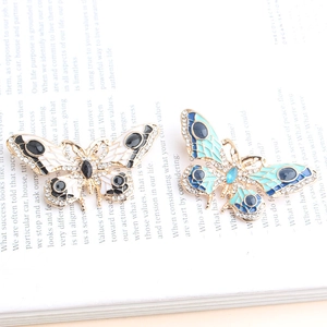 Elegante vintage vlinderbroches met blauw en wit email en fonkelende strass-steentjes