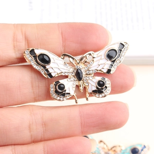 Detailopname van een vintage vlinderbroche met fonkelende kristallen en emaille vleugels