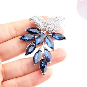 Eleganter silberner Blatt-Anstecker mit weißen Diamanten und tiefblauen Schmucksteinen