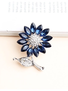 Detailed view of silver sunflower brooch with blue crystal petals and white zircon