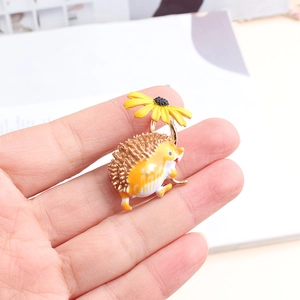 Détail de la broche hérisson en émail tenant un parapluie tournesol en main