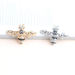 Elegante goldene und silberne Honigbienen-Brosche mit Strass auf einem Buch