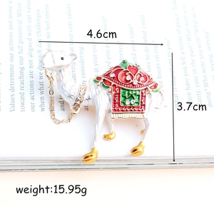 Broche lama en émail blanc avec selle rouge et verte, strass brillants et chaîne dorée