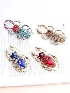 Detail of four colorful vintage alloy beetle brooches with crystal rhinestones