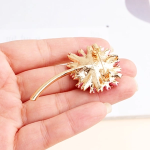 Handheld daisy flower brooch in gold-plated alloy with pink enamel and matte metal finish