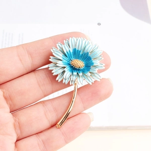 Detailed view of daisy flower brooch featuring blue and white gradient enamel and gold stem