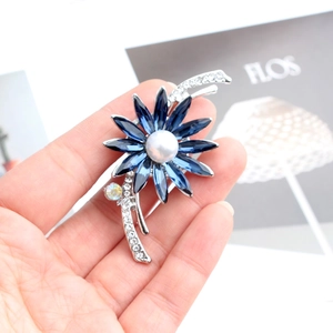 Détail de la broche fleur avec pierres marquises bleues, perle et tige en cristal