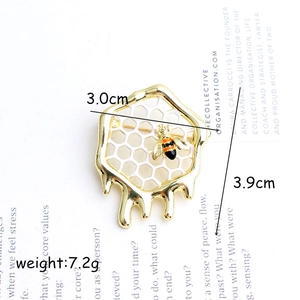 Eleganter Bienen- und Waben-Brosche mit weißer Emaille und Gold-Honigtropfen-Details