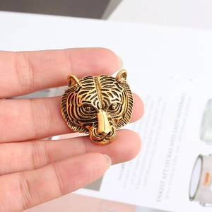 Détail macro de broche tête de tigre en laiton vintage montrant l'artisanat du relief