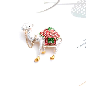 Broche alpaga en émail blanc avec selle colorée, strass brillants et fine chaîne dorée