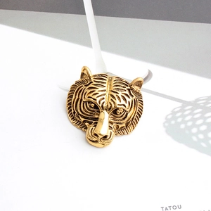 Macro d'une broche tête de tigre en bronze montrant les reliefs et textures détaillés