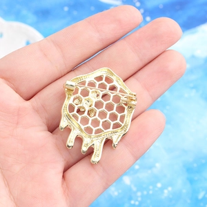 Goldene Bienenwabe Brosche mit fließendem Design und Sicherheitsverschluss auf der Rückseite