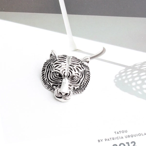 Vue détaillée de la broche tête de tigre en argent vintage avec des textures ciselées