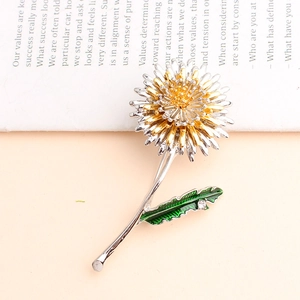 Detail of silver dandelion brooch with green enamel leaf and dual-tone metal petals