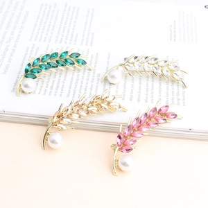 Close-up of wheat-shaped alloy brooches with colorful rhinestones and pearls