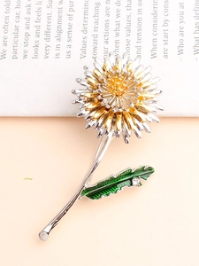 Detail of dandelion brooch with gold silver petals and green enamel leaf and zircon