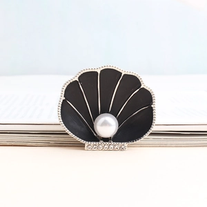 Detail of scallop shell brooch featuring black enamel with pearl and rhinestone accents