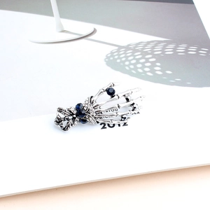 Macro shot of silver skeleton hand brooch with blue gems and white crystals