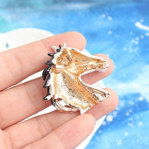 Vintage horse head brooch in gold metal with black and white enamel finish