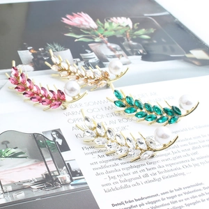 Detail of wheat ear earrings with vibrant marquise crystals and elegant white pearls