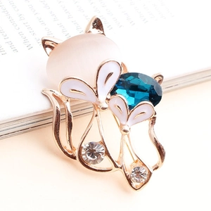 Eleganter Fuchs-Anstecker mit rosa Opal und blauem Kristall auf Vintage-Buch