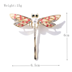Elegant dragonfly brooch with pink enamel wings and pearl detail on white background