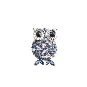 Sparkling silver owl brooch with deep blue crystals and black gem eyes on white background