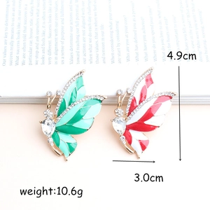 Vintage alloy butterfly brooches with enamel wings and white diamonds on magazine