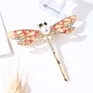 Detailed view of the enamel dragonfly brooch featuring a pearl center and rhinestones.