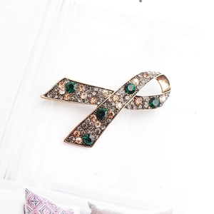 Elegant ribbon brooch in vintage bronze alloy with green rhinestones and champagne crystals