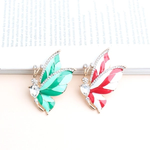 Detail of butterfly brooches featuring green and red enamel with sparkling rhinestones