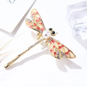 Golden dragonfly brooch with yellow enamel wings and pearl detail on white background
