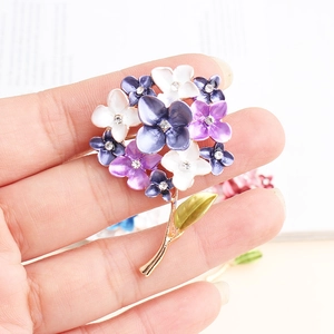 Macro detail of enamel flower brooch with purple petals and sparkling rhinestones